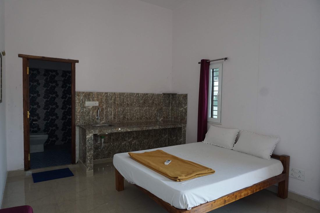 Jala room G2, Art Le Cafe Auroville — bed and en-suite bathroom entrance