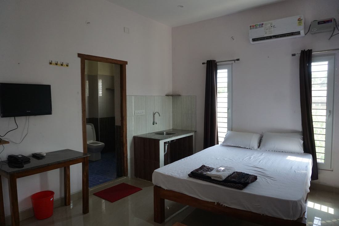 Vayu room G4, Art Le Cafe Auroville — bed, TV and sink area