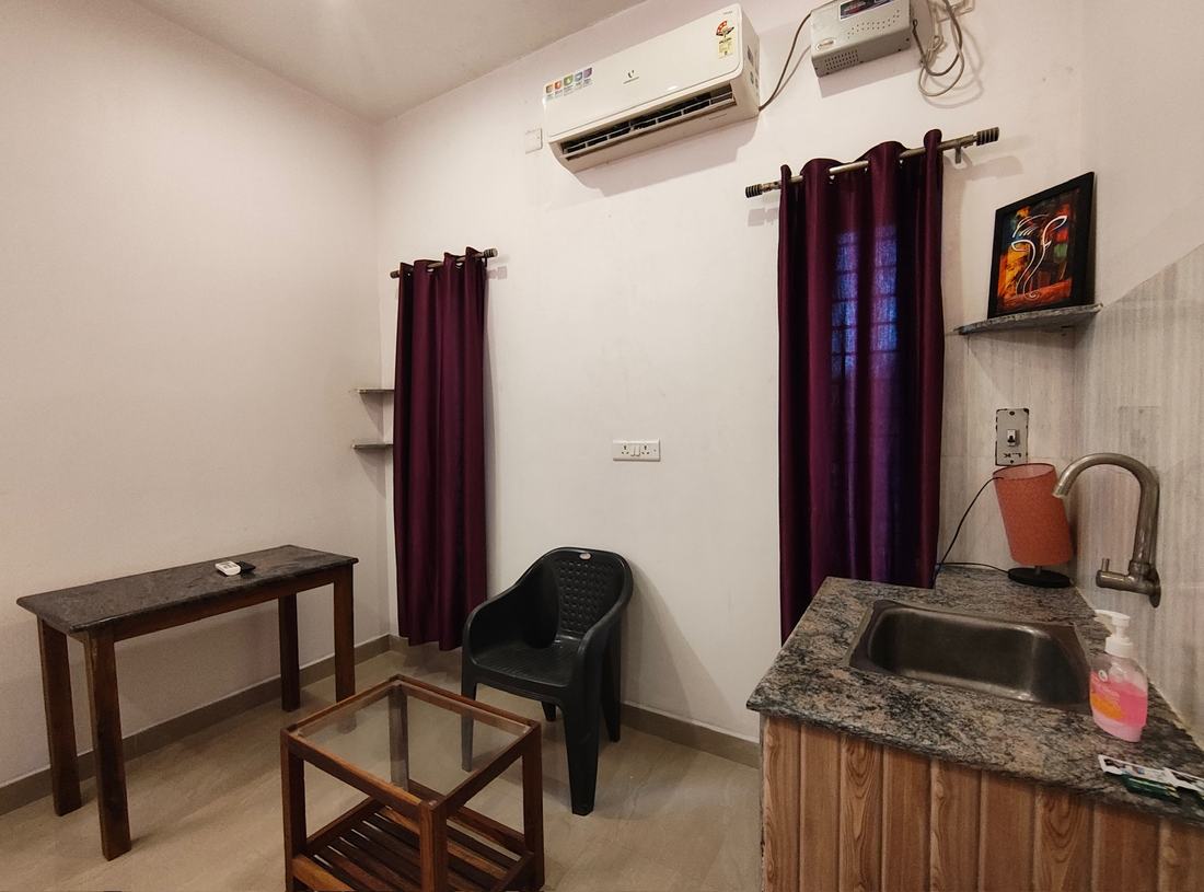 Aakash room G5, Art Le Cafe Auroville — sitting area with AC and sink