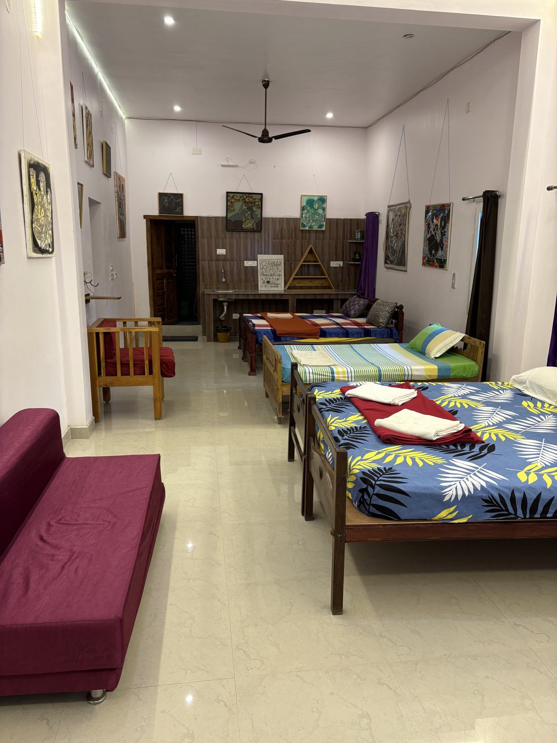 Room G6, Art Le Cafe Auroville — beds with artwork on walls