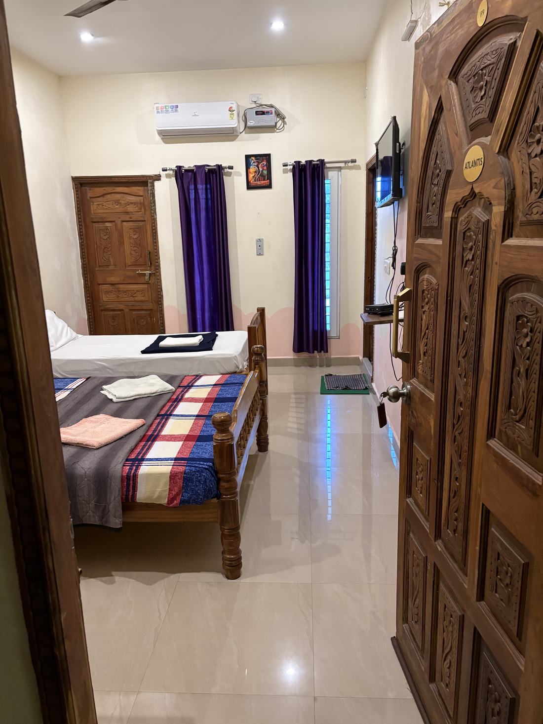 Atlantis room F9, Art Le Cafe Auroville — entrance and bed with AC and TV