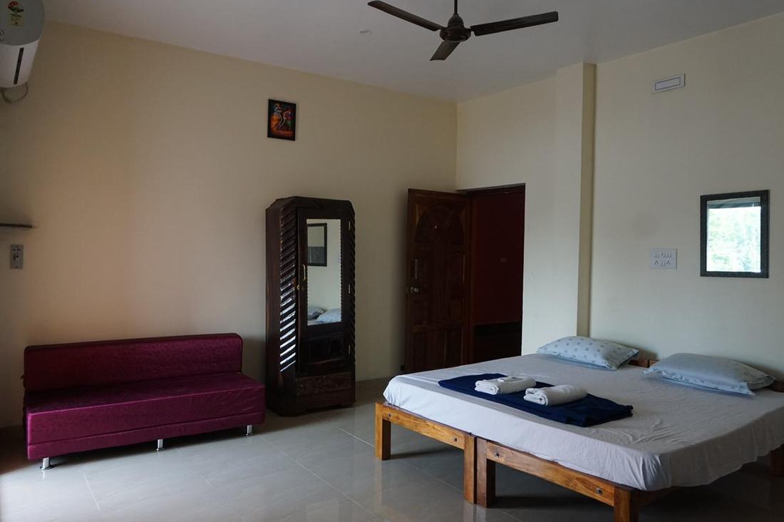 Ganesha room S17, Art Le Cafe Auroville — bed, sofa and wardrobe